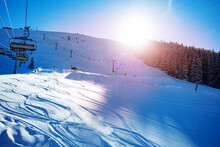 Ski Lift On Alpine Resort With Sunset Over Mountain Range