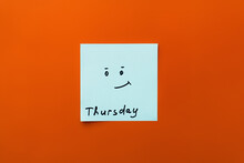 Top View Of Sticky Note With Thursday Inscription And Positive Smiley On Orange Background.