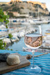 Rose wine in glass served with goat cheeses on outdoor terrace with view on old fisherman's harbour with colourful boats in Cassis, Provence, France