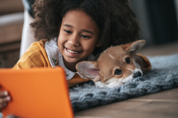 Wall Mural - A girl lying with her puppy and making selfie