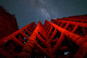 Wall Mural - Night landscape photography. Old check dam in the starry night.  Bright milkyway galaxy.