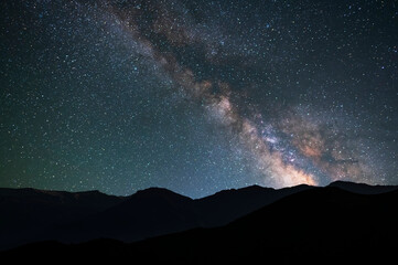 Wall Mural - beautiful bright milky way galaxy at the night sky and hills silhouette. astronomical background.