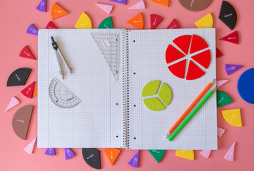 Geometry Set on open notebook.  Compass Drawing Tool, ruler, pencils, multicolored fractions for mathematical education. Math Drafting Dividers Tool, set for school, study. Back to school concept