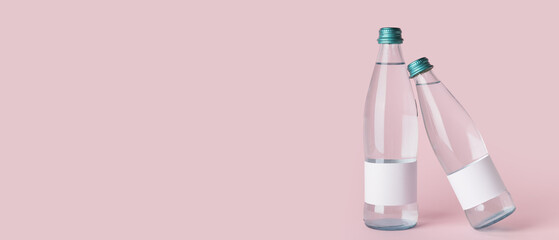 Bottles of clean water on pink background with space for text