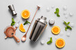 Different cocktail utensils and ingredients on grey background