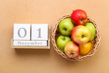 Basket with apples and cube calendar with date NOVEMBER 1 on color background. World Vegan Day concept