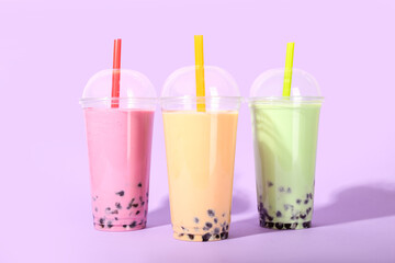 Sticker - Plastic cups of tasty bubble tea on purple background