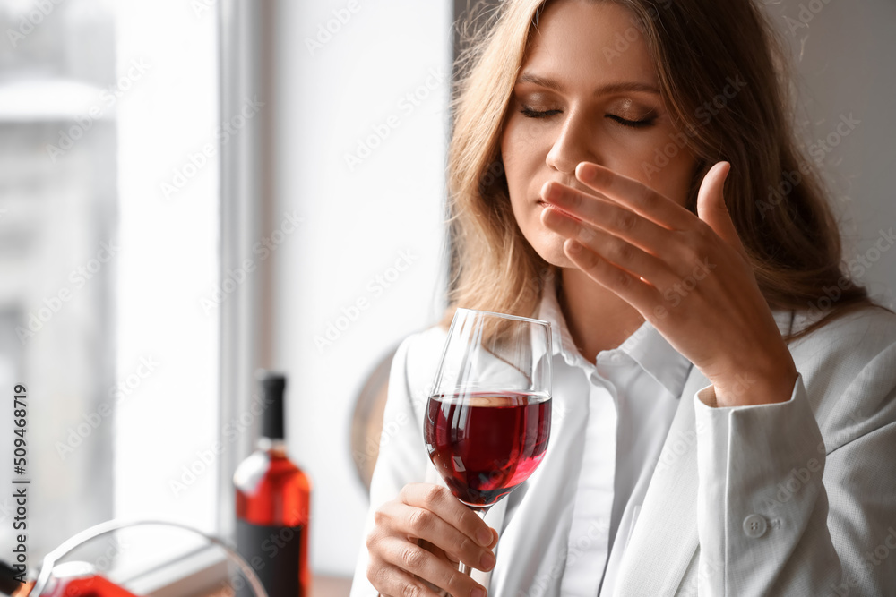 Beautiful young female sommelier tasting types of wine