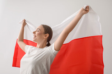 Sticker - Beautiful young woman with flag of Poland on light background