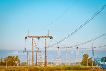 High voltage electricity tower with power line against blue sky. Overhead electric power line with insulators. Electricity generation, transmission, and distribution network. Indastry landscape.