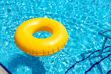Wall Mural - Yellow inflatable ring floating in swimming pool. Vacation concept with copy space