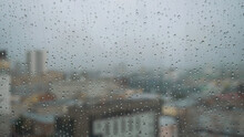 Rain Drops On Glass With A Background. Stock Footage. Raindrops On The Window On The Background Of The City