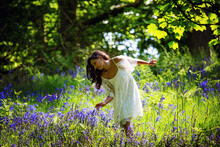 Indian Lady Picking Wildflowers In The Middle Of A Blue Bell Wood