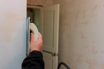 Sticker - Apartment renovation with worker applies checking levelling to wall a using grinding spatula