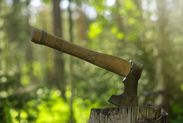 An axe for chopping wood will be stuck into a wooden stump.Chop wood. A metal axe with a wooden handle.