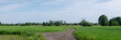droga na środku łąki, krajobraz w rejonie zachodniej polski zielone drzewa błękitne niebo