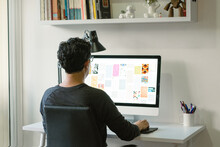Latin Man Working Remotely. Graphic Design Professional Working From Home. Creative Making Illustrative Designs On His Computer. Home Office With Minimalist Design. 