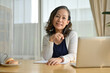 © bongkarn - Asian aged woman sits in the living room in front of the portable computer.