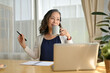 © bongkarn - Positive asian aged woman enjoying with her morning coffee and using laptop computer.