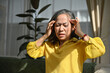 © bongkarn - Unhappy asian senior aged-woman with headache expression, touching her head