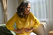 © bongkarn - Unhappy asian aged woman feeling discomfort in abdomen, stomach ache.