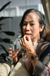 © bongkarn - Portrait of an asian aged woman taking a vitamin, taking care of herself.