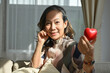 © bongkarn - Charming asian senior retired aged woman holding a red heart shape. Healthcare medical