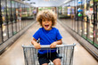 © Brocreative - Funny little boy laughing while sitting in a shopping cart during a family trip to the grocery store. He is excited to buy something new