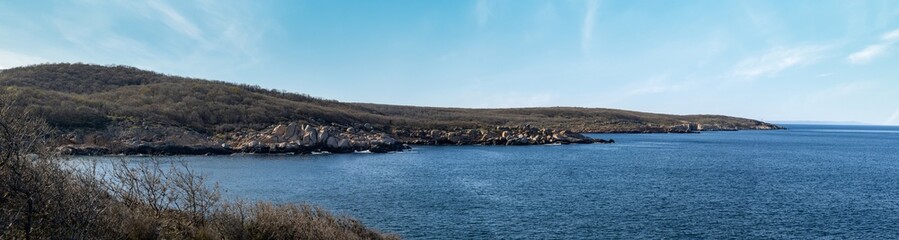 Wall Mural - Panorama of a beach with sand and stones near the Black Sea under sunset light in Bulgaria