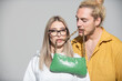 © Volodymyr - Woman and man holds fashion handbag in mouth. Close up outdoor fashion portrait of stylish young pretty couple in love hugs. Ladies handbag.