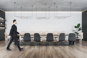 Poster - Attractive young european businessman walking in contemporary loft meeting room interior with wooden parquet flooring, furniture and decorative items. Law and legal, worker, ceo, consulting concept.