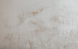 A drywall plastered surface with rough brush strokes texture. Paint brushed old white wall background.