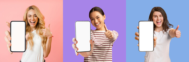 Pretty multiracial ladies showing smartphones with empty screens and thumb ups