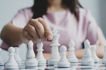 Wall Mural - Hand of businesswoman moving, chess in competition shows leadership, followers, and business success strategies