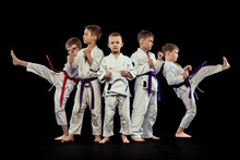 Group Portrait Of Preschool Age Boys, Beginner Karate Fighters In White Doboks Posing Like Team Isolated On Dark Background. Concept Of Sport, Martial Arts, Education