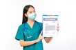 © Png - Video - Photo - Portrait of professional asian female smiling doctor in green scrubs pointing fingers to clipboard health insurance Self-isolation, social distancing.