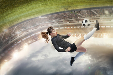 Sticker - Young female soccer or football player with long hair in sportwear and boots kicking ball for the goal in jump at the stadium.