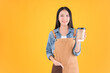 © Png - Video - Photo - pretty asian female smile coffee freelancer open coffee shop show present and poing to coffee paper cup small business and startup concept yellow background.