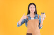 © Png - Video - Photo - pretty asian female smile coffee freelancer open coffee shop show present and poing to coffee paper cup small business and startup concept yellow background.