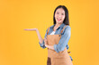 © Png - Video - Photo - pretty asian female smile coffee freelancer own shop ands point up and pose to copy space yellow background.