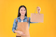 © Png - Video - Photo - pretty asian female smile freelancer own shop show paper bags to customers buy products yellow background.