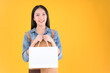 © Png - Video - Photo - pretty asian female smile freelancer own shop show paper bags to customers buy products yellow background.