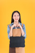 © Png - Video - Photo - pretty asian female smile in apron freelancer small business and startup concept. asian woman open shop showing blackboard for adding text yellow background.