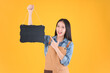 © Png - Video - Photo - pretty asian female smile in apron freelancer small business and startup concept. asian woman open shop showing blackboard for adding text yellow background.