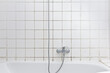 © agenturfotografin - Rental damage concept: grimy shower in bath tub with black mold growing on calcifications on the tile grouting in a neglected old bathroom.