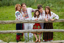 Cheerful Family With Kids In Traditional Romanian Dress In A Countryside, Park. Father, Mother, Son And Daughters Posing Outside.