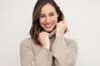© Martin Villadsen - Beautiful young woman posing and looking cute in camera with both hands. Wearing a warm sweater and smiling.