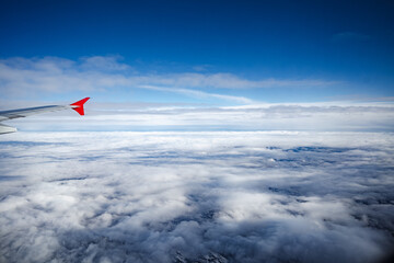 Wall Mural - aircraft wing above beautiful clouds and blue sky
