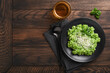 Italian risotto. Delicious risotto with pesto sauce or wild garlic pesto, basil, parmesan cheese and glass of white wine on old wooden table background. Italian dinner. Top view with copy space.