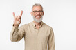 © InsideCreativeHouse - Cheerful smiling caucasian mature middle-aged man with grey hair and glasses showing rock-n-roll gesture, listening to rock heavy music isolated in white background